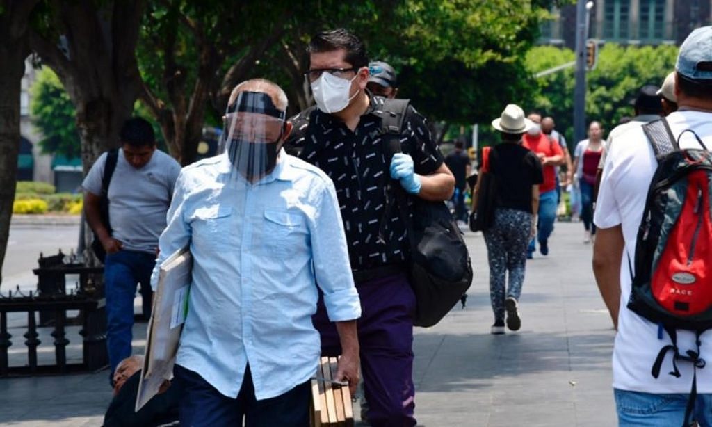 Fotografía de ciudadanos siguiendo las medidas sanitarias del uso de cubrebocas y caretas