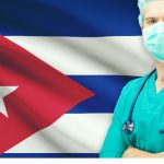 Médico frente a la bandera de Cuba