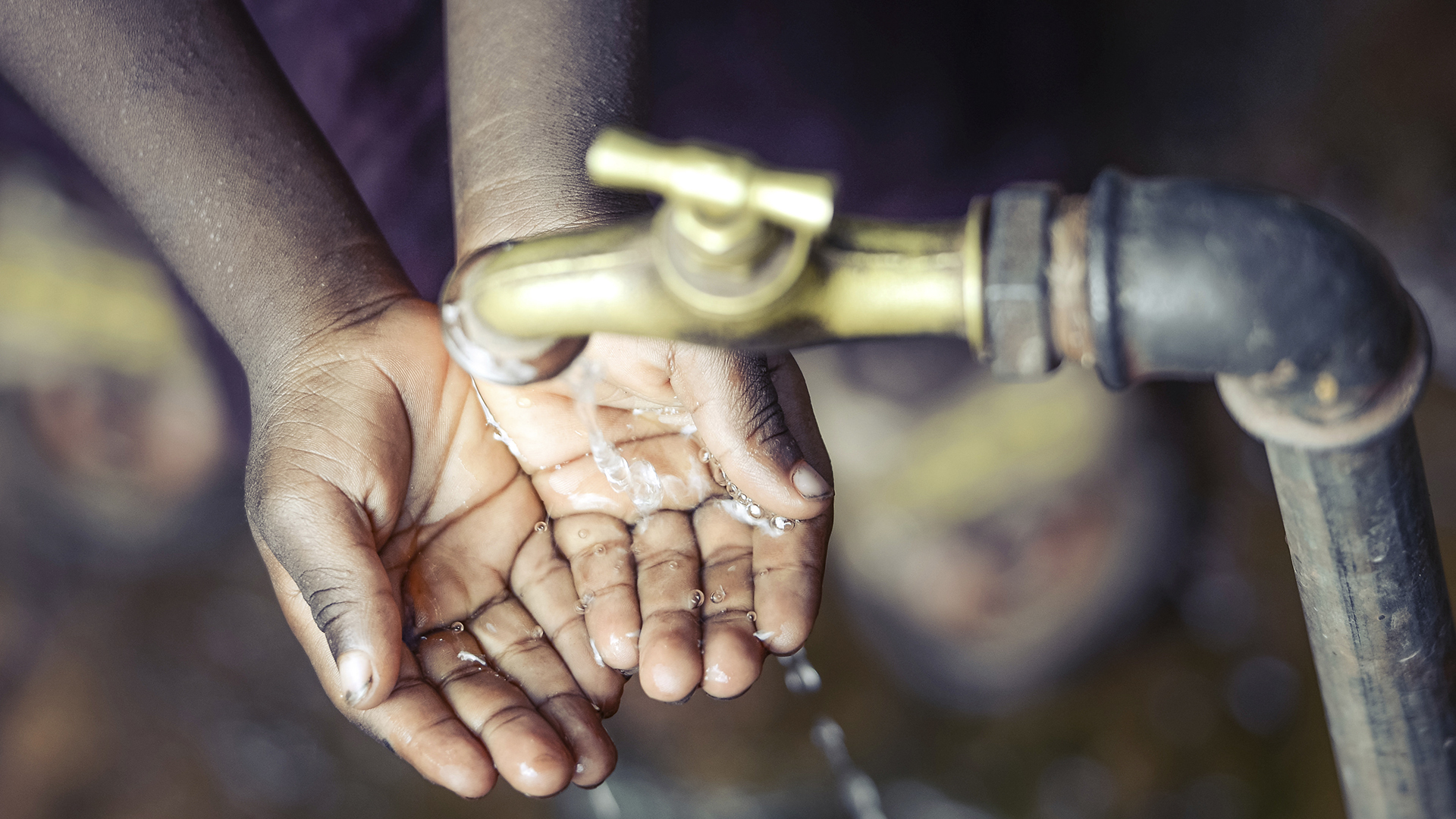 Mujer se lava las manos en una toma de agua que puede tener arsenico
