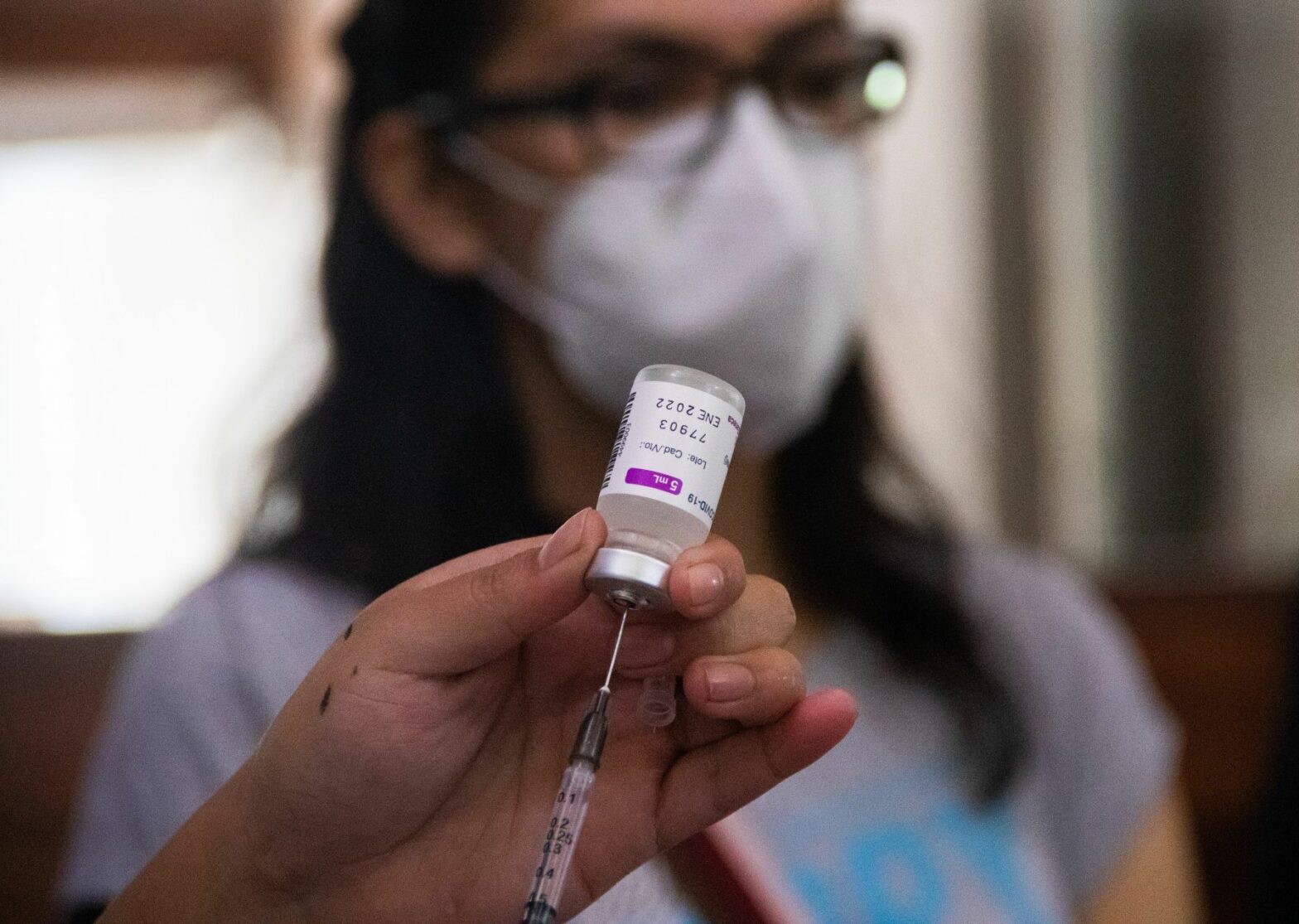 Imagen de un medico sacando la sustancia para vacunar a los adultos