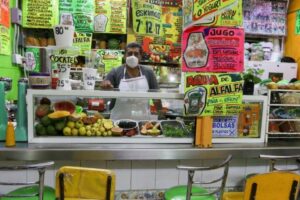 Un señor aiende un puesto de comida en un mercado