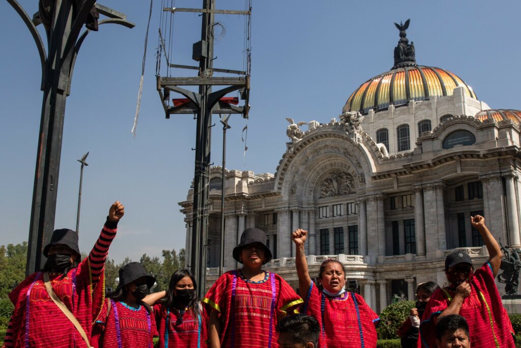 Indígenas de la región triqui. Al fondo el palacio de Bellas Artes