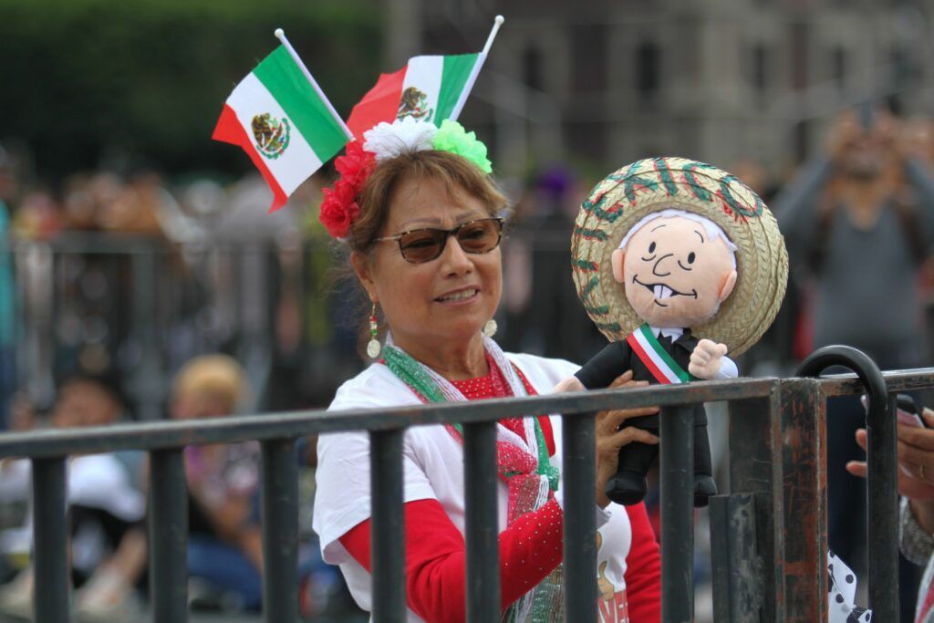 Señora con un muñeco del presidente de México, Andrés Manuel López Obrador